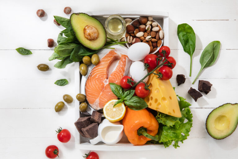 salmone, avocado, mandorle e pomodori su tavola bianca